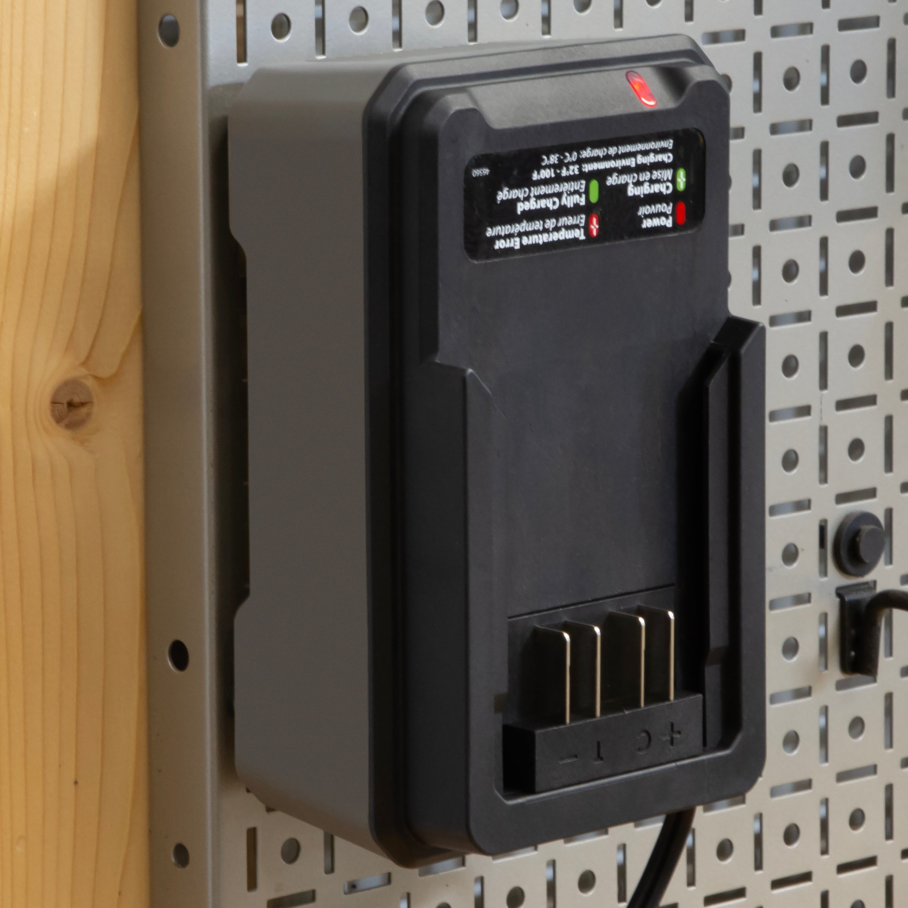 Battery charger mounted on a pegboard wall