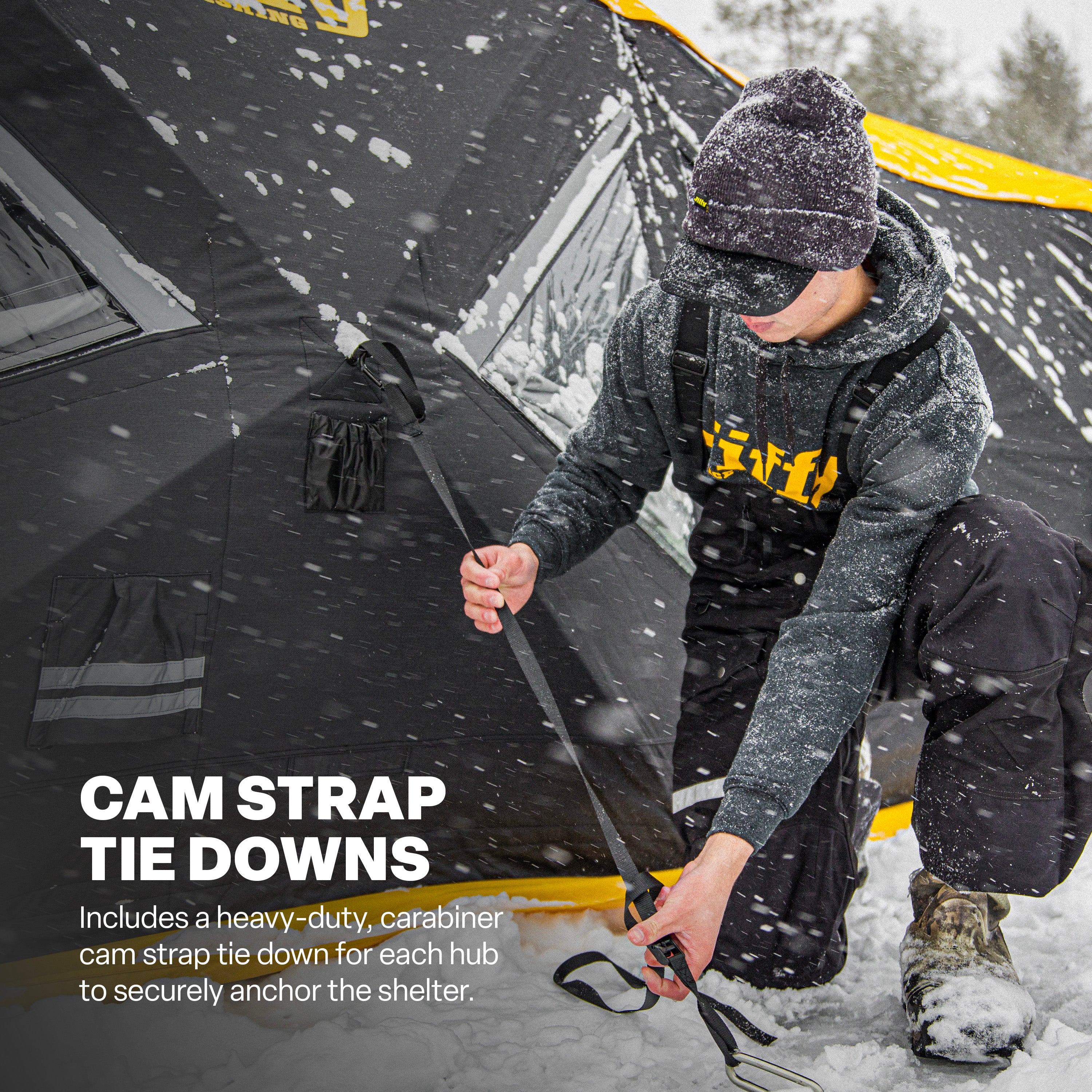 Person setting up a snow-covered tent with cam strap tie downs