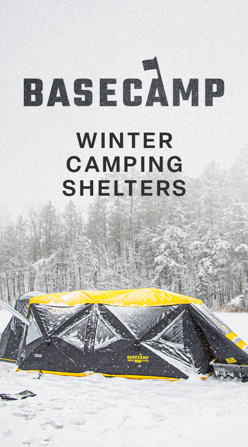 Basecamp winter camping shelter in a snowy landscape with trees.