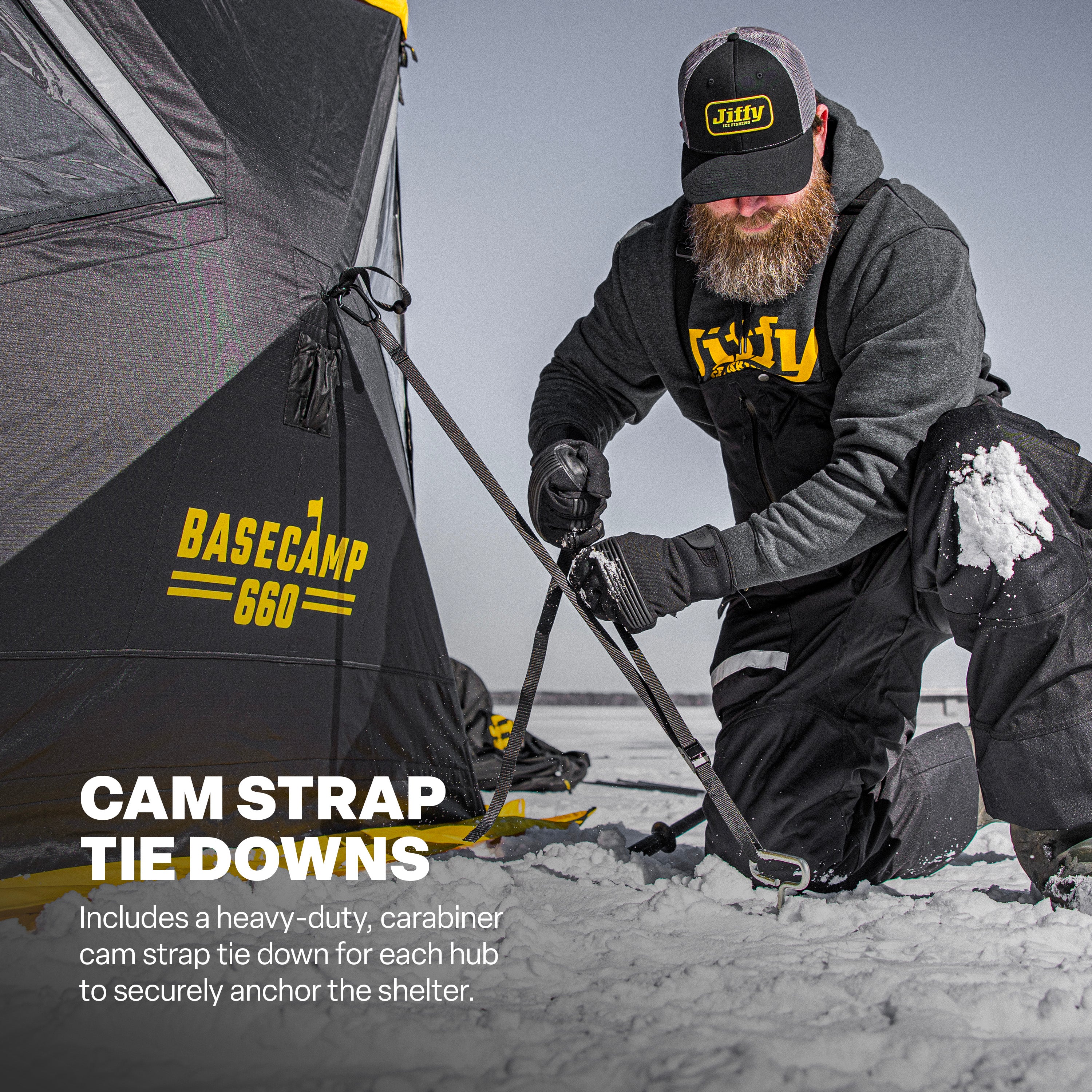 Person setting up a Basecamp 660 tent with cam strap tie downs in a snowy environment.